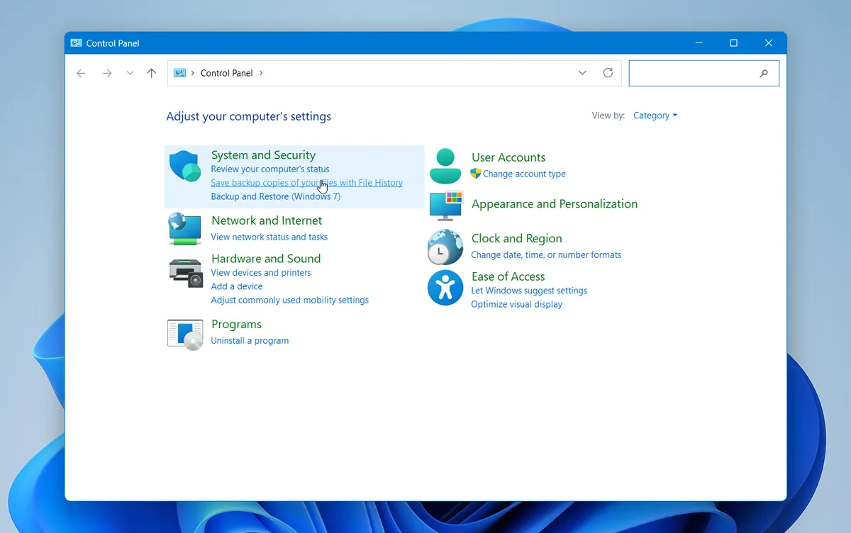Windows Control Panel with the File History backup option under System and Security